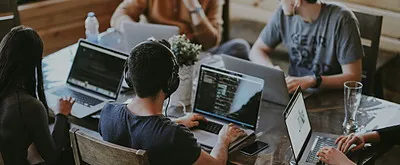 Ortak masada dizüstü bilgisayarlarla çalışılan ofis