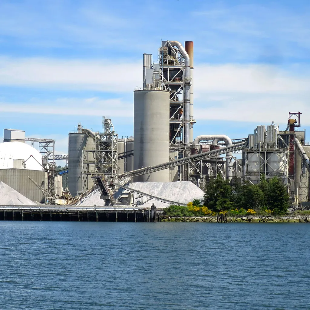Deniz kıyısında silo ve ön ısıtıcı kulesiyle çimento fabrikası