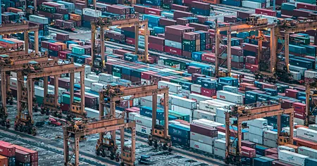 Konteyner sahasında istif makineleri ve dizilmiş konteynerler