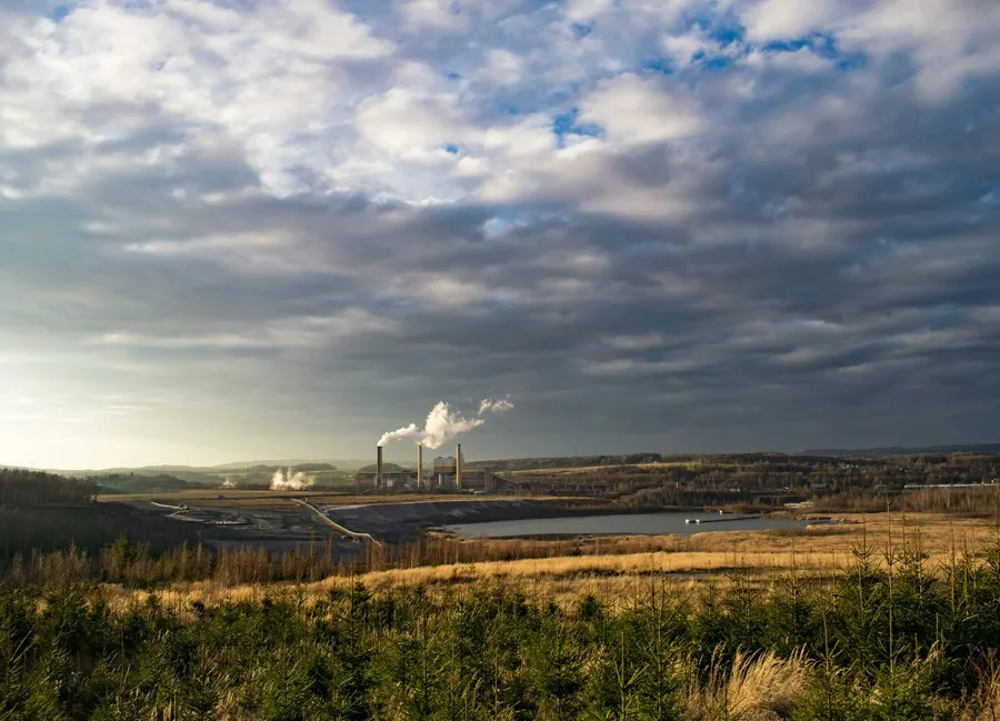 Uzakta bacaları görünen enerji tesisi ve çevresindeki arazi